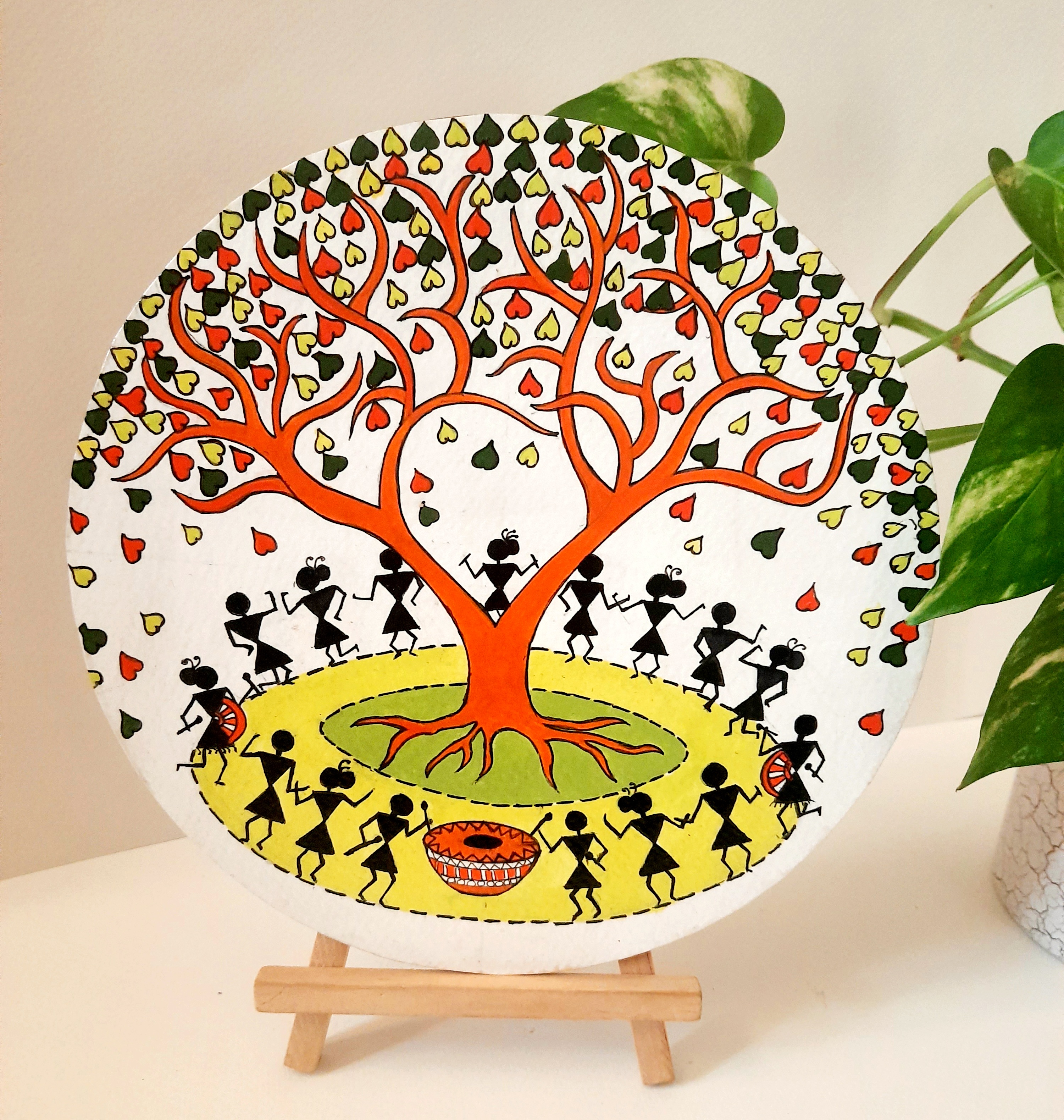 Warli painting of village life on 8" round mdf plate with stand